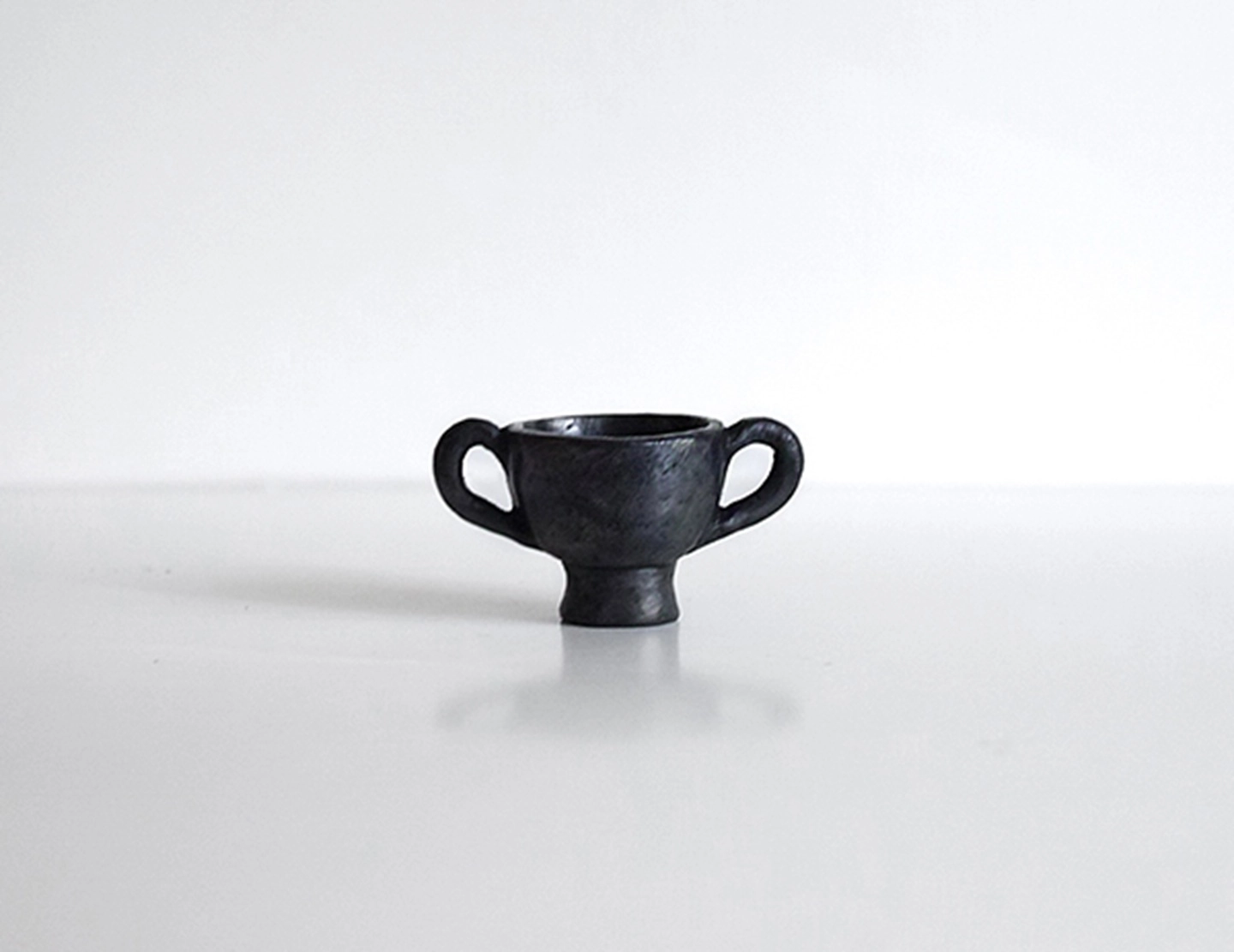 Front view of the SUPERTIBET Tibetan black pottery dancing figurine incense holder.