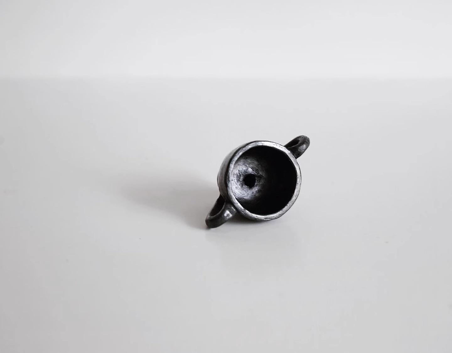 Interior detail and texture of the kiln-fired Tibetan black pottery incense holder.