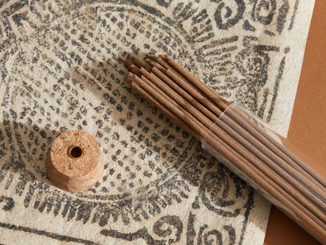 Detail shot of SUPERTIBET Traveler Small incense sticks showing natural botanical texture and the portable glass tube.