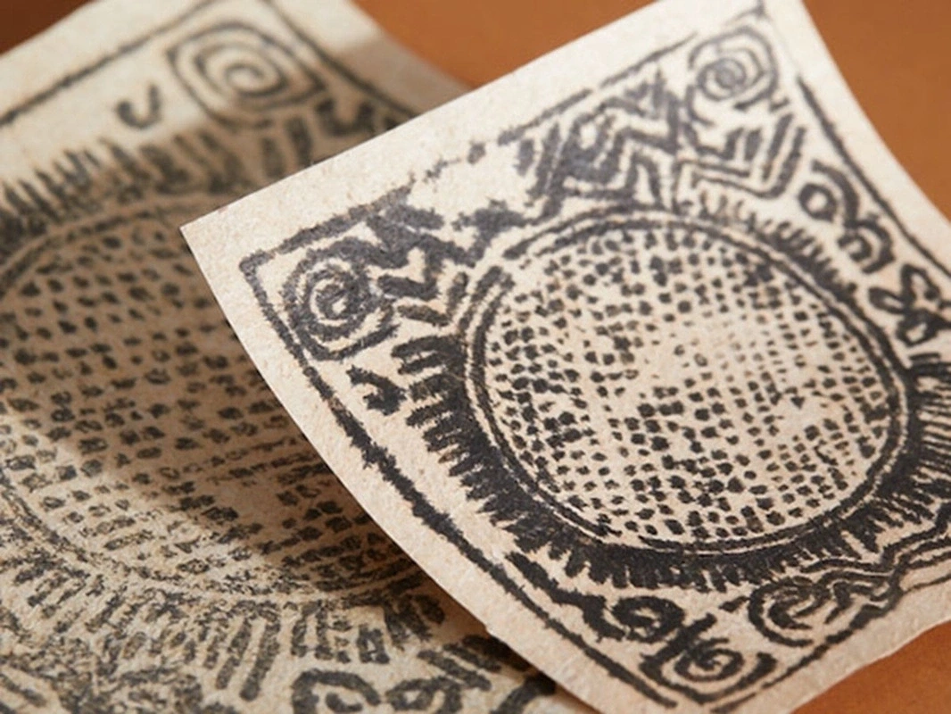 Close-up of woodblock-printed Gyama ritual motifs on Rangtang handmade Tibetan paper.