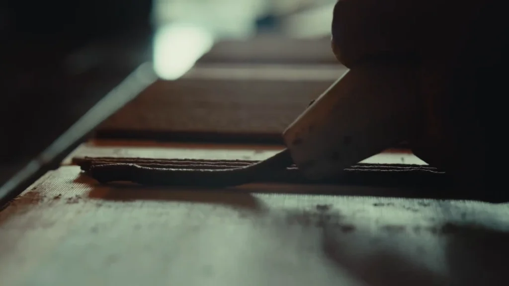 Close-up of hands shaping freshly pressed Tibetan incense paste into even strands.