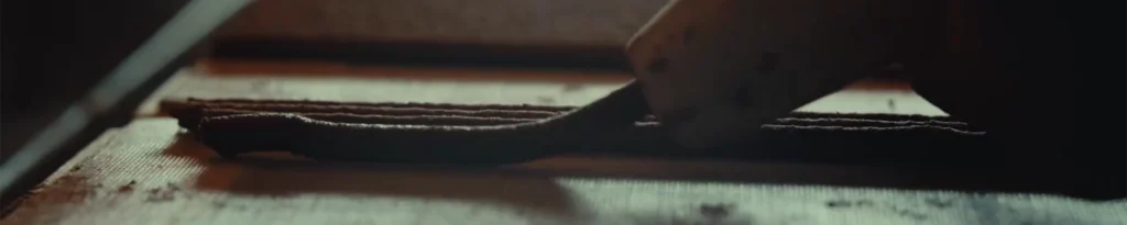 Close-up of wet Tibetan incense paste being pressed through an ox horn into long strands.